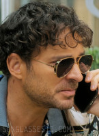 Manolo Cardona as Danger Carmelo wears gold aviator sunglasses in Medusa.