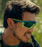 Simu Liu wears yellow and blue Oakley Jawbreaker sunglasses in the movie Arthur The King.