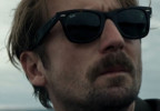 Tom Basden wears a pair of Ray-Ban 2140 Wayfarer sunglasses in the movie The Ballad of Wallis Island.