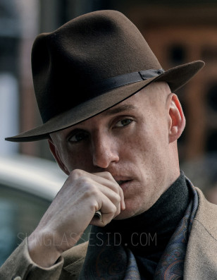 Eddie Redmayne wearing a Lock & Co Hatters hat, Omega watch and Oliver Peoples Mandeville sunglasses in the series The Day of the Jackal.