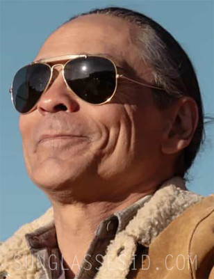Zahn McClarnon wears Ray-Ban Outdoorsman sunglasses while riding a motorcycle in Dark Winds 