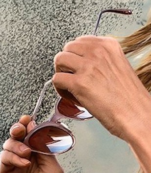 The glasses have a matte pink (or vintage rose) frame and gradient lenses and a silver round logo on the temple tips.
